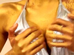 Slender ladyboy in golden body paint strips and strokes her